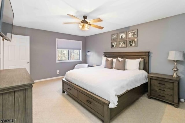 bedroom with a ceiling fan, baseboards, and light carpet