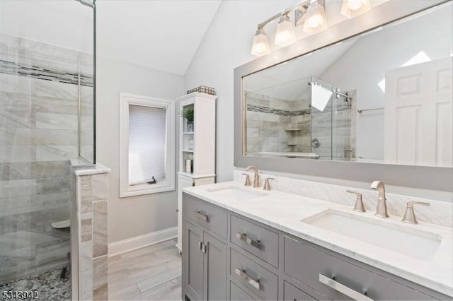 full bathroom featuring a sink, lofted ceiling, double vanity, and a shower stall