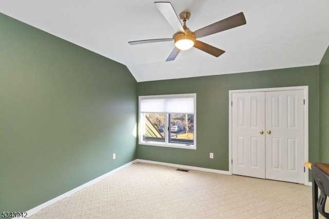 bedroom with lofted ceiling, visible vents, baseboards, and a closet