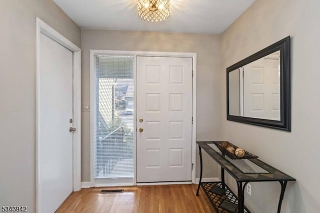 foyer entrance featuring baseboards and wood finished floors