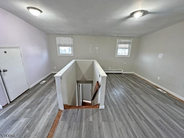 spare room with dark wood finished floors, baseboards, and a baseboard radiator