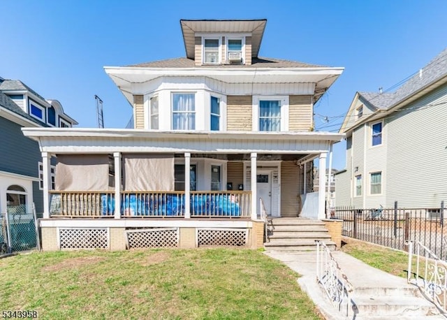 traditional style home featuring a front lawn, fence, and covered porch