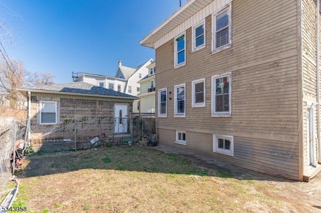 rear view of property with a yard and fence