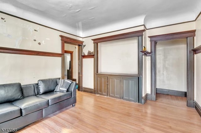 living area featuring light wood-type flooring and ornamental molding