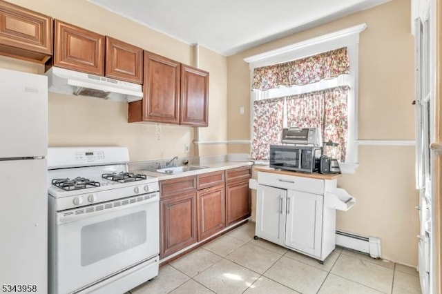 kitchen featuring under cabinet range hood, baseboard heating, brown cabinetry, white appliances, and a sink