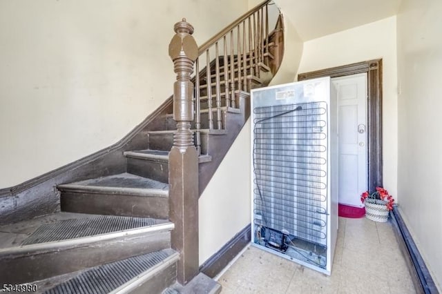 staircase featuring a heating unit and baseboards