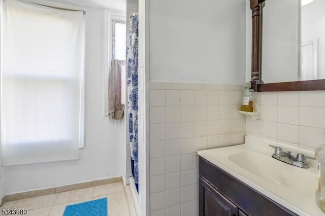 bathroom with tile patterned floors, curtained shower, tile walls, and vanity