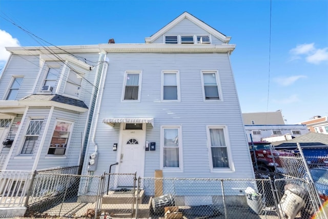 townhome / multi-family property with a fenced front yard and a gate