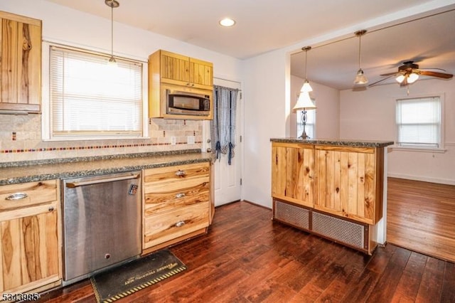 kitchen featuring dark countertops, dark wood-style floors, a ceiling fan, and appliances with stainless steel finishes