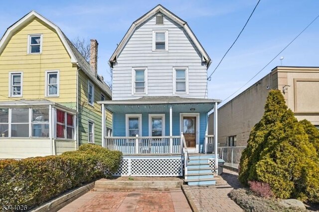 view of front facade featuring covered porch and a gambrel roof