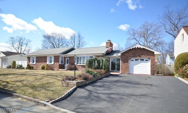 single story home featuring an attached garage, fence, brick siding, and driveway