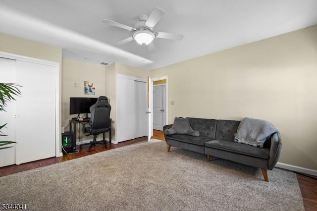 sitting room with visible vents, baseboards, wood finished floors, and a ceiling fan