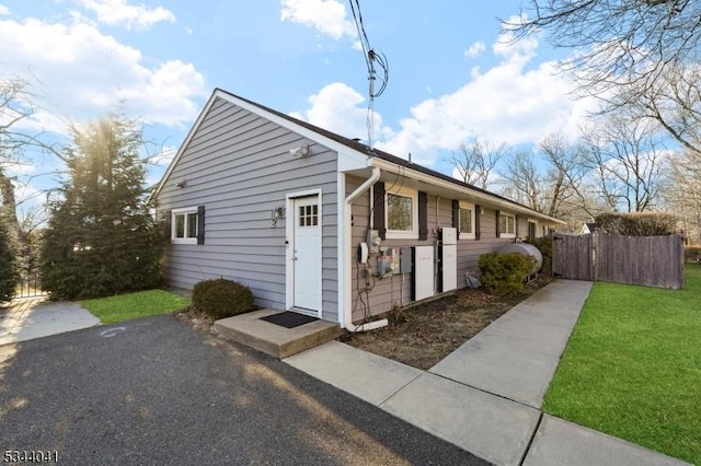 view of front of home with a front yard and fence