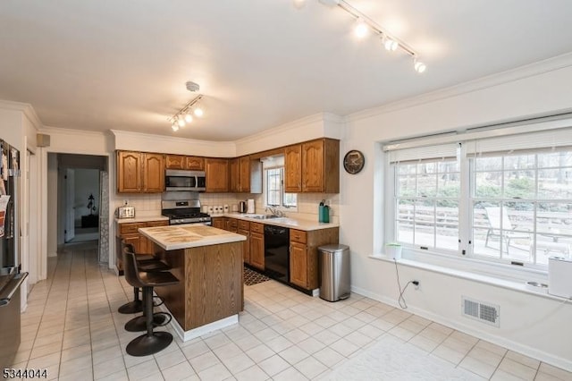 kitchen featuring backsplash, stainless steel appliances, light countertops, and brown cabinets