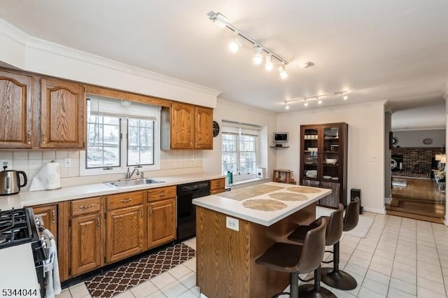 kitchen with crown molding, range with gas cooktop, dishwasher, a breakfast bar area, and a sink