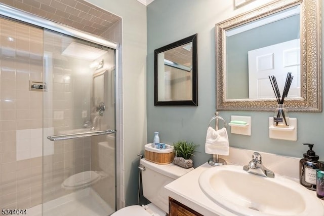 bathroom featuring a shower stall, toilet, and vanity