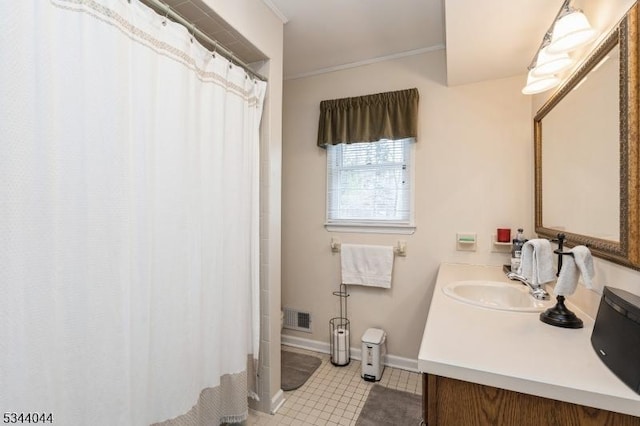 bathroom featuring vanity, baseboards, visible vents, tile patterned flooring, and crown molding