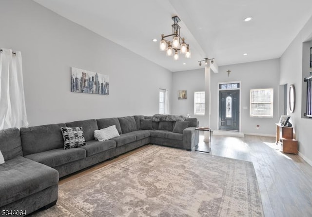 living area featuring baseboards, an inviting chandelier, and wood finished floors