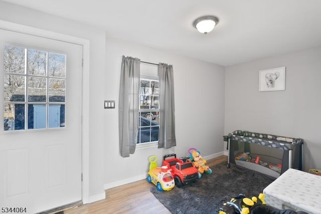 recreation room with baseboards and wood finished floors