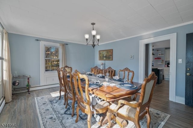 dining room featuring baseboards, a notable chandelier, wood finished floors, and crown molding