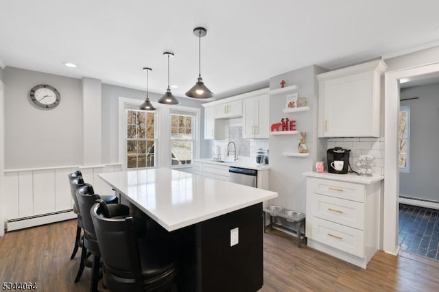 kitchen featuring a sink, light countertops, white cabinets, dark wood-type flooring, and baseboard heating