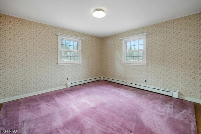 empty room with baseboards, a baseboard heating unit, plenty of natural light, and carpet floors