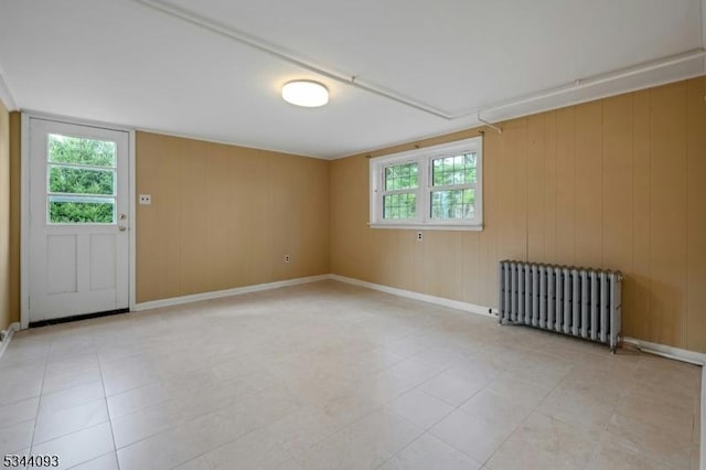 empty room featuring radiator and baseboards