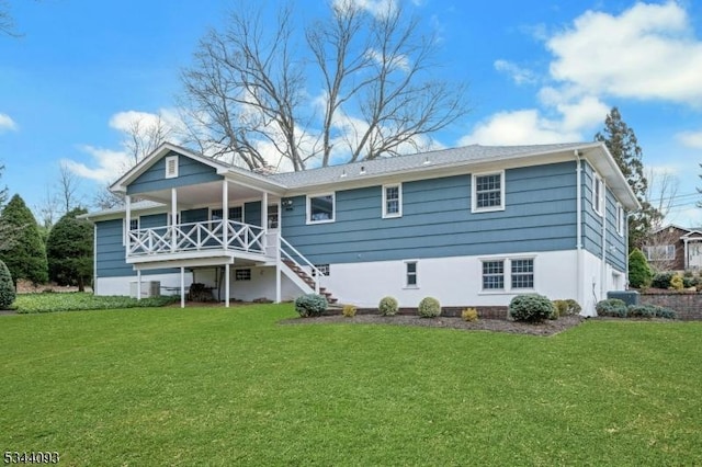 rear view of property with stairway, central AC, and a yard