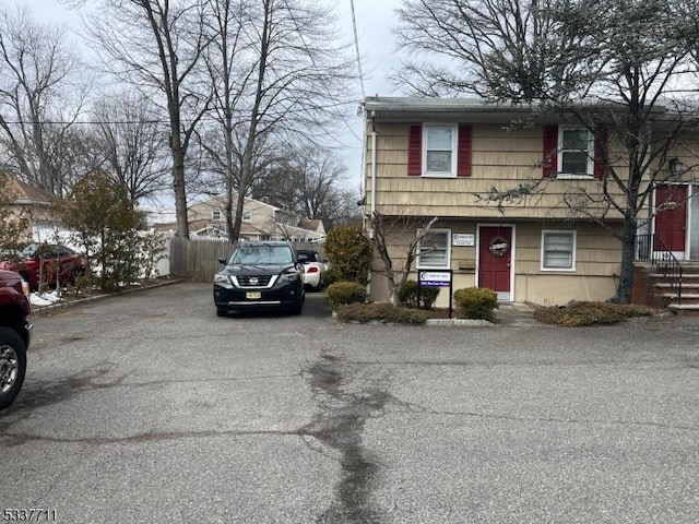 view of front facade with driveway and fence