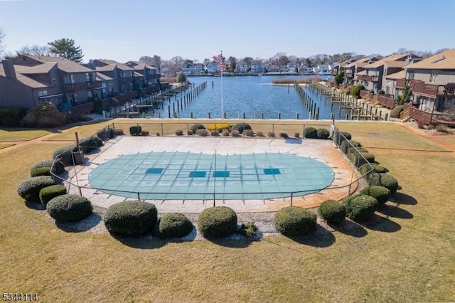 pool with a residential view, a lawn, fence, and a water view