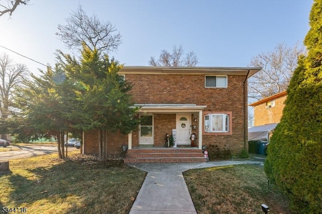 traditional-style house featuring brick siding and covered porch