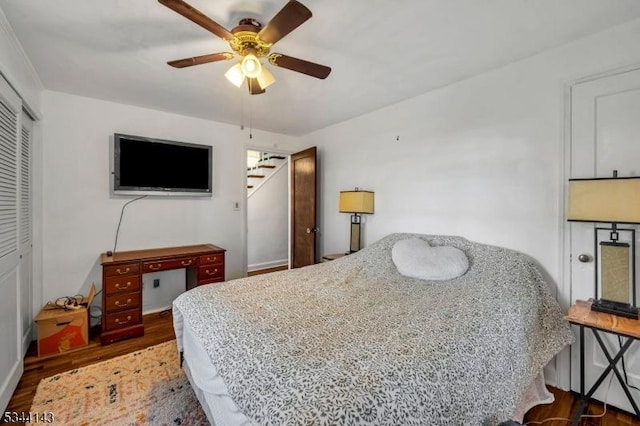 bedroom featuring a ceiling fan, a closet, and wood finished floors