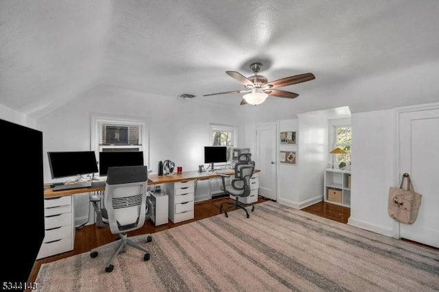 office space with a ceiling fan, vaulted ceiling, a wealth of natural light, and visible vents