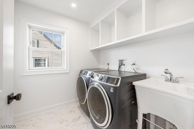 clothes washing area with washing machine and clothes dryer, baseboards, laundry area, marble finish floor, and a sink