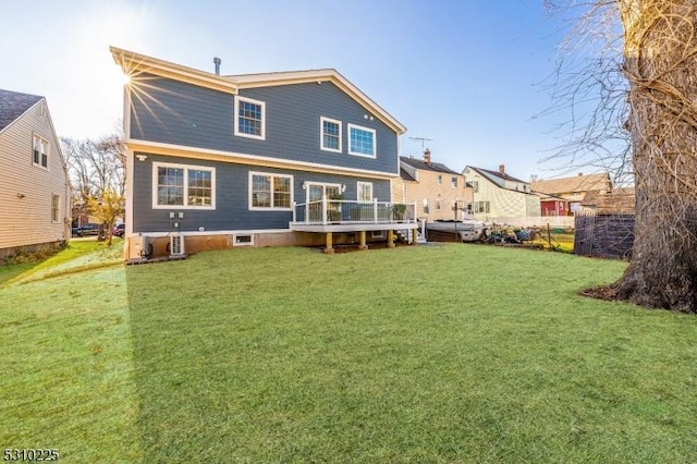 back of property featuring a deck and a yard