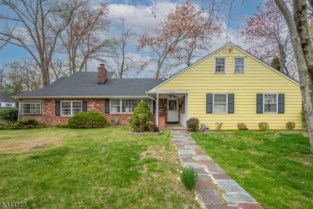 view of front of house with a front lawn, brick siding, and a chimney