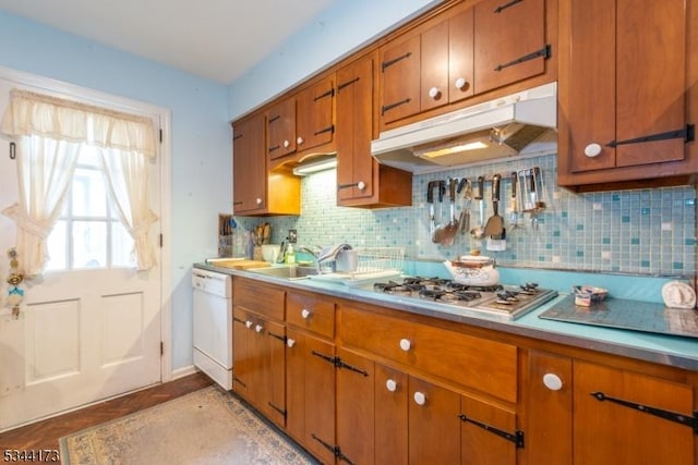 kitchen with a sink, brown cabinets, dishwasher, and under cabinet range hood