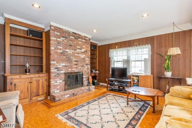 living area with crown molding, a brick fireplace, built in features, and wood walls