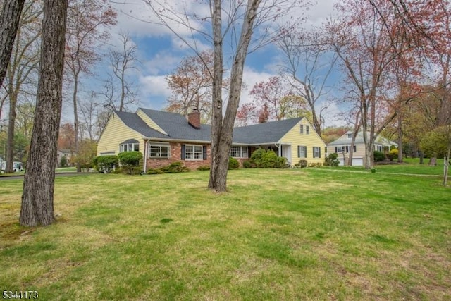 view of front of house with a front lawn, brick siding, and a chimney