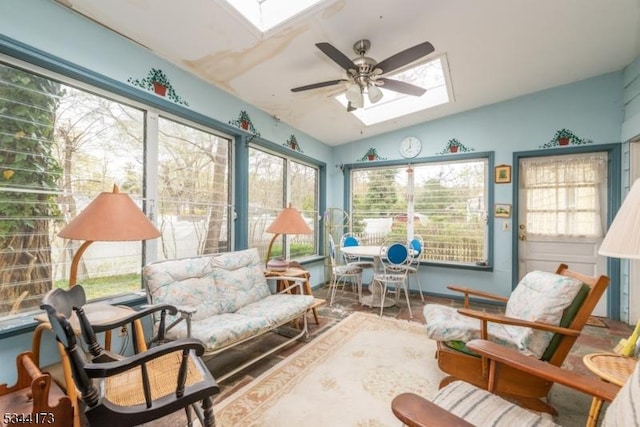 sunroom / solarium featuring lofted ceiling with skylight and wood finished floors
