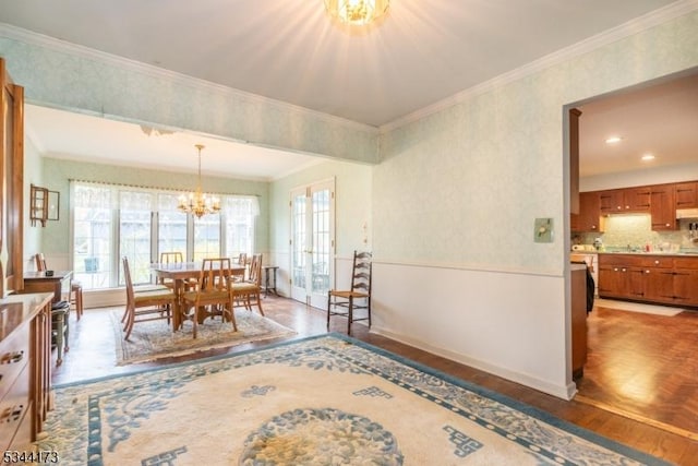 dining space with a chandelier, wood finished floors, a wealth of natural light, and ornamental molding