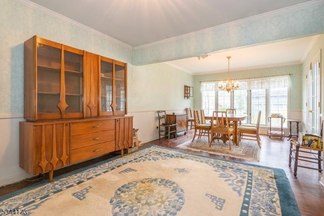dining room featuring wood finished floors, ornamental molding, a notable chandelier, and wallpapered walls