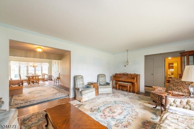 living room featuring crown molding, a notable chandelier, and wood finished floors