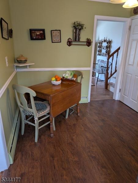 dining area with a baseboard heating unit and wood finished floors