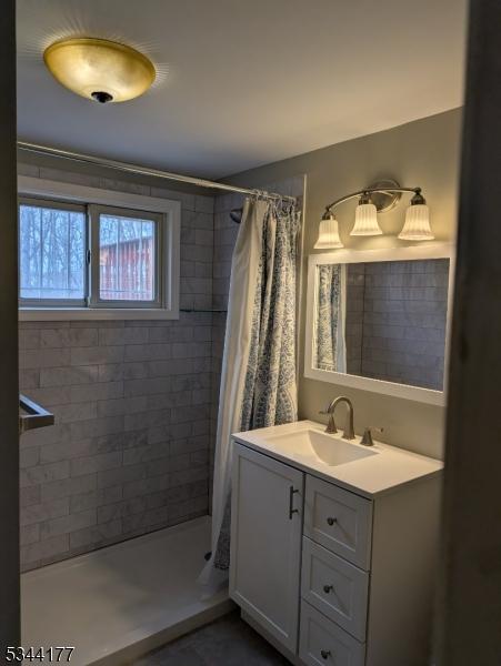 bathroom featuring vanity and a tile shower