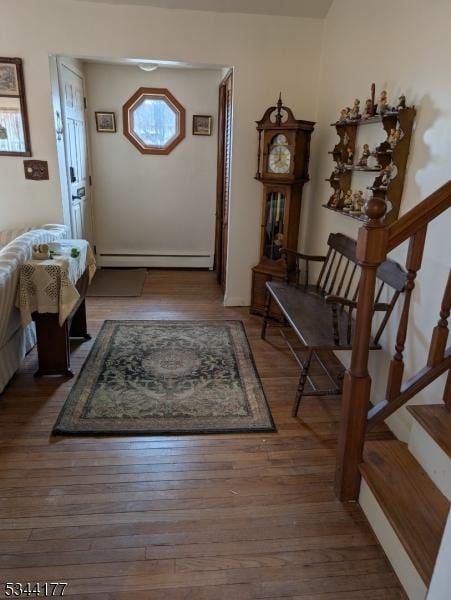 entryway with stairs, wood finished floors, and a baseboard radiator