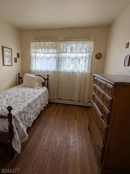 bedroom featuring multiple windows and dark wood-style flooring