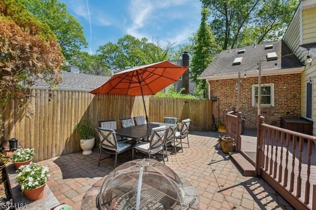 view of patio with a fire pit, a fenced backyard, and outdoor dining space