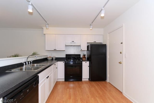 kitchen with white cabinetry, rail lighting, under cabinet range hood, a sink, and black appliances