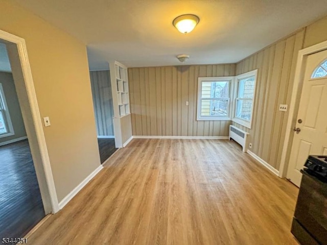 entrance foyer featuring radiator, baseboards, and light wood-type flooring